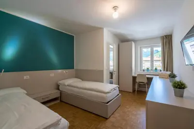 a bedroom with a bed and a desk and a table at Stay COOPER l Capitol Rooms in Bolzano