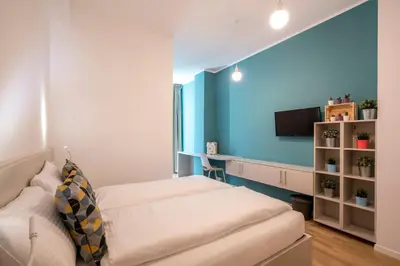 a bedroom with two beds and a blue wall at Stay COOPER l Capitol Rooms in Bolzano