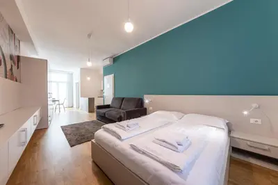 a bedroom with a bed and a chair in a room at Stay COOPER l Capitol Rooms in Bolzano