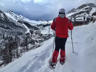 a man is skiing down a snow covered mountain at Hotel Genziana in Arabba