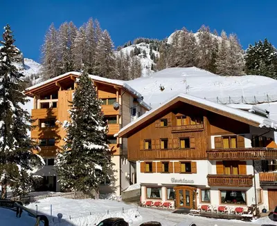 a ski lodge in the snow with a christmas tree at Hotel Genziana in Arabba