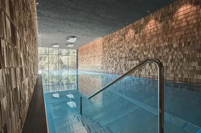 a large swimming pool in a building with at Tenne Lodges in Racines