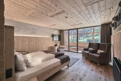 a bedroom with a bed and a couch and a chair at Tenne Lodges in Racines
