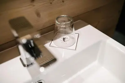 a glass jar sitting on top of a bathroom sink at Tenne Lodges in Racines