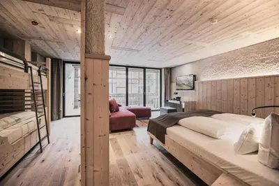 a bedroom with two bunk beds and a chair at Tenne Lodges in Racines