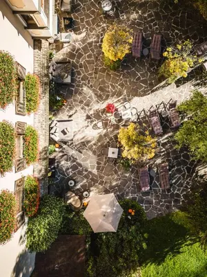 an overhead view of a patio with tables and umbrellas at Romantik Hotel & Restaurant Stafler in Vipiteno
