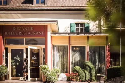 a woman standing in front of a hotel restaurant at Romantik Hotel & Restaurant Stafler in Vipiteno