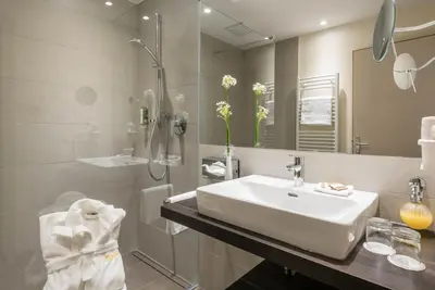 a bathroom with a sink and a shower and a mirror at Romantik Hotel & Restaurant Stafler in Vipiteno