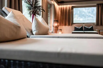 a row of beds with pillows in a room at Romantik Hotel & Restaurant Stafler in Vipiteno