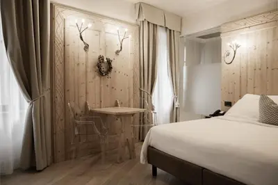 a bedroom with a large bed in a room at Hotel Orso Grigio in Cavalese
