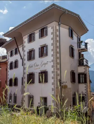 a white building with a sign on it at Hotel Orso Grigio in Cavalese
