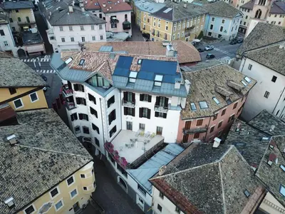 a bedroom with a bed and a table and chairs at Hotel Orso Grigio in Cavalese