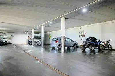 a parking garage with cars and motorcycles parked in it at B&B Villa Pattis in Vipiteno