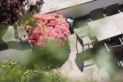 an overhead view of a garden with a table and pink flowers at Garni Juval in Tirolo