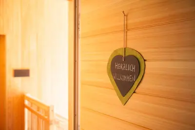 a heart shaped sign on a wooden wall at Winklerhof Apartments in Brunico