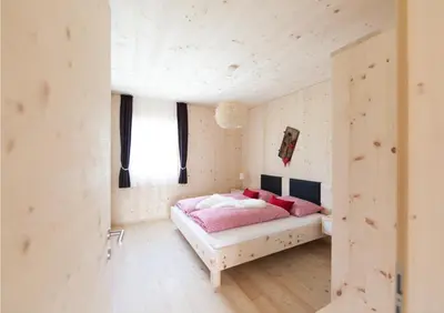 a bedroom with a pink bed in a room at Winklerhof Apartments in Brunico