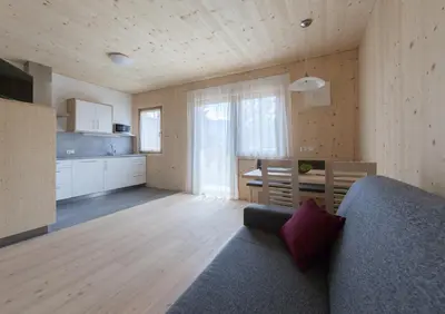 a living room with a couch and a kitchen at Winklerhof Apartments in Brunico