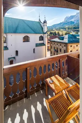 a balcony with a table and chairs and a view at Hotel Montana in Cortina dʼAmpezzo