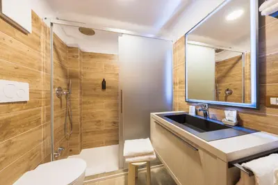 a bathroom with a sink and a shower at Hotel Montana in Cortina dʼAmpezzo