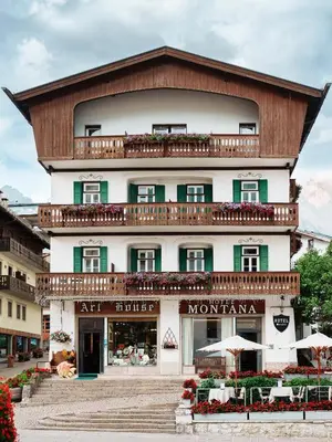 a large building with a balcony on top of it at Hotel Montana in Cortina dʼAmpezzo