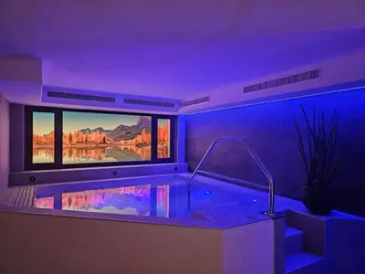 a bathroom with a tub with a large window at Hotel Mirabel in San Vigilio Di Marebbe