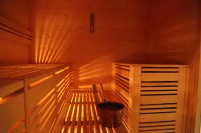 a wooden sauna with a bucket in it at Hotel Mirabel in San Vigilio Di Marebbe