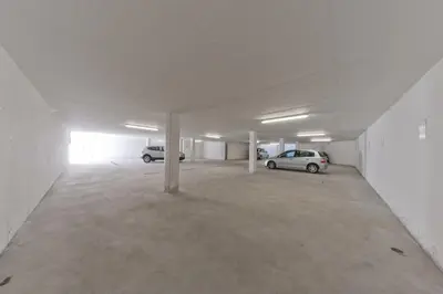 an empty parking lot with two cars parked in it at Hotel Mirabel in San Vigilio Di Marebbe