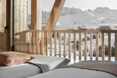a bedroom with a balcony with a view of a snow covered mountain at ICARO Hotel in Alpe di Siusi