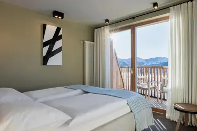 a bedroom with a bed and a large window at ICARO Hotel in Alpe di Siusi