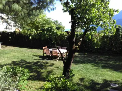 a table and bench in a yard with a tree at Haus Tinkhauser in Vilpiano