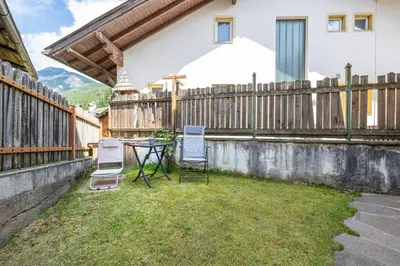 a patio with two chairs and a table and a fence at Apartments Smidl in Ortisei