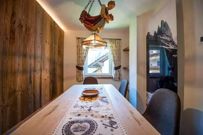a dining room with a wooden table and chairs at Apartments Smidl in Ortisei