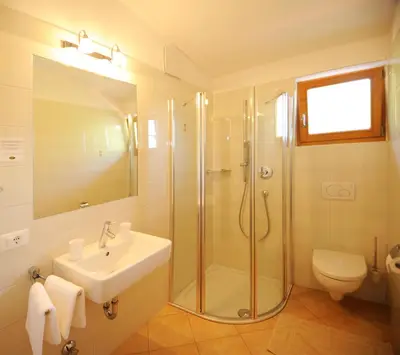 a bathroom with a shower and a sink and a toilet at Pension Golser in Cermes