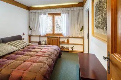 a bedroom with a bed and a window at Villa Franchetti - Stayincortina in Cortina dʼAmpezzo