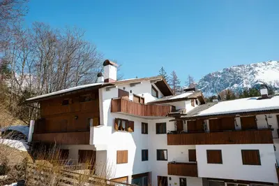 a white building with snow on the roof at Villa Franchetti - Stayincortina in Cortina dʼAmpezzo