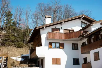 a white building with wooden balconies on it at Villa Franchetti - Stayincortina in Cortina dʼAmpezzo