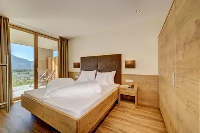 a bedroom with a large bed and a large window at Panorama Residence Öhlerhof in Lagundo