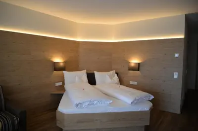 a bedroom with a bed with white sheets and pillows at Panorama Residence Öhlerhof in Lagundo