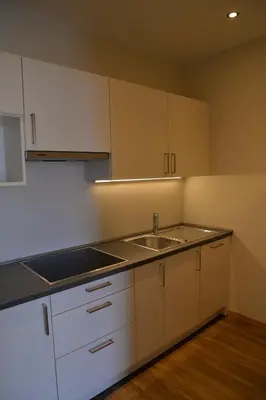 a kitchen with white cabinets and a sink at Panorama Residence Öhlerhof in Lagundo