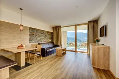 a living room with a dining table and a couch at Panorama Residence Öhlerhof in Lagundo