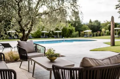 a patio with a table and chairs and a pool at Hotel Ansitz Rungghof in Appiano sulla Strada del Vino