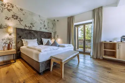 a bedroom with a bed and a large window at Hotel Ansitz Rungghof in Appiano sulla Strada del Vino