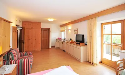 a living room with a television and a kitchen at Seppmair in Lagundo