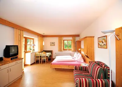 a bedroom with a bed and a couch and a tv at Seppmair in Lagundo