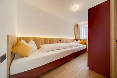 a bedroom with a bed with white sheets and yellow pillows at Residence & Sportlodges Claudia in Plaus