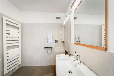 a white bathroom with a sink and a shower at Residence & Sportlodges Claudia in Plaus
