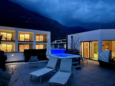 a patio with a table and chairs and a building at Residence & Sportlodges Claudia in Plaus