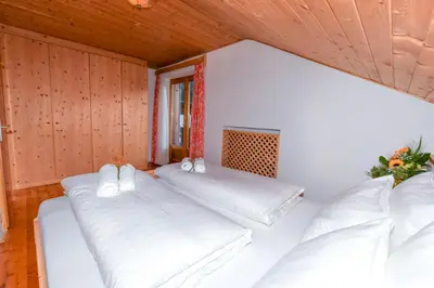 a room with two beds with white pillows at Appartamenti Chedul in Selva di Val Gardena