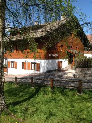 a wooden building with a fence in front of it at Appartamenti Chedul in Selva di Val Gardena