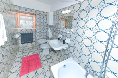 a bathroom with a white sink and a toilet at Appartamenti Chedul in Selva di Val Gardena